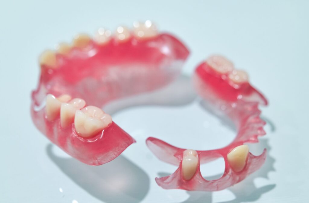 A flexible partial denture sits on a shiny blue background.