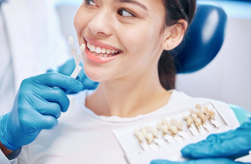 Patient smiling while looking at potential veneer shade options during a consultation.