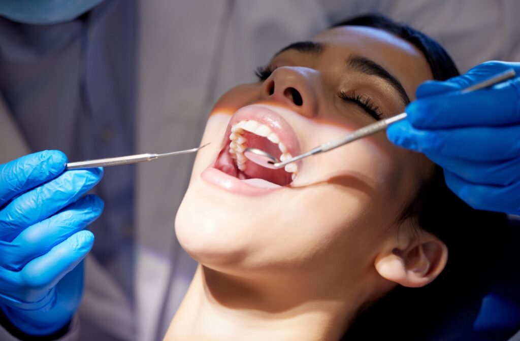 Woman receiving a dental exam to support oral health and help prevent cavities and fillings.